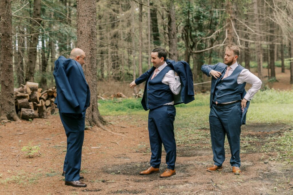 Groom getting ready with groomsmen outside in the woods													
